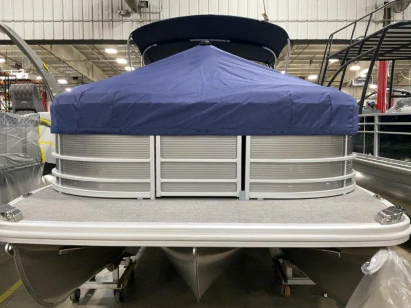 Slide: The Image of 2024 Bennington 25 RSR pontoon boat with blue cover in a showroom. - 9