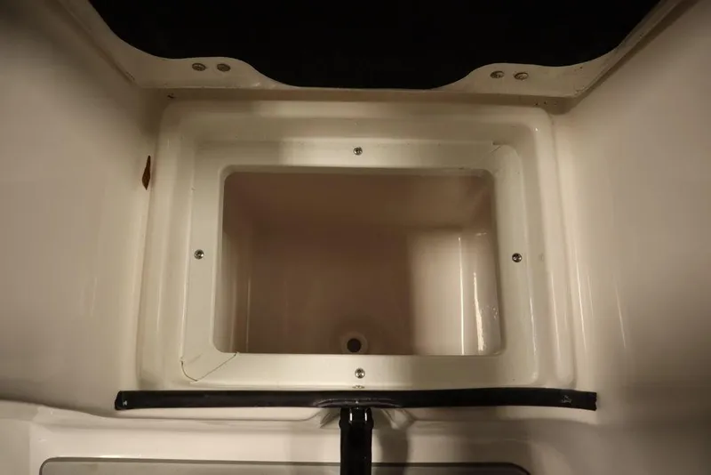 Slide: The Image of Sea Fox 248 Commander 2025 storage compartment, open and empty, with white interior. - 49