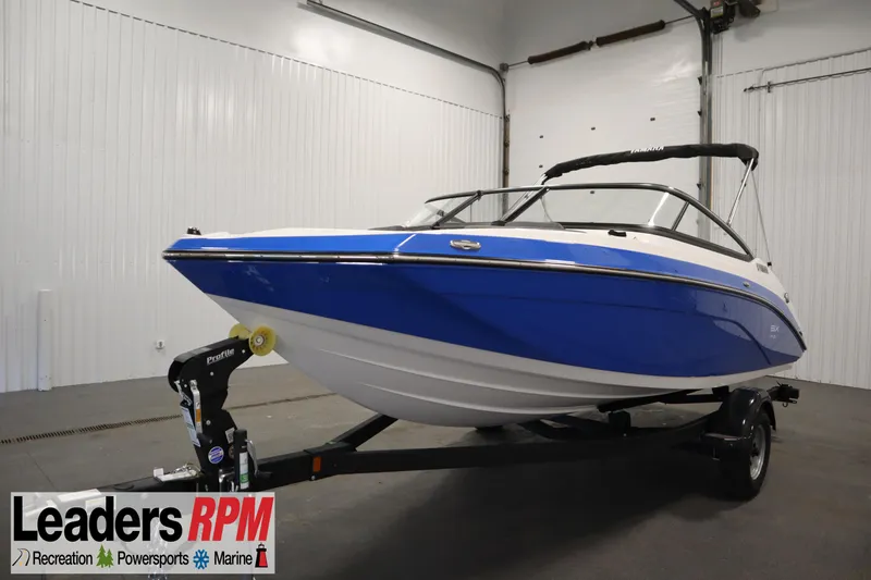The Image of 2025 Yamaha Boats 195 SX in showroom, blue and white design, on trailer. - 0