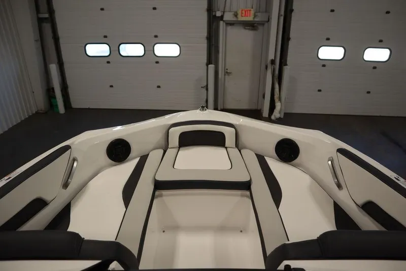 Slide: The Image of 2025 Yamaha Boats SX195 interior with sleek seating and modern design in a garage setting. - 12