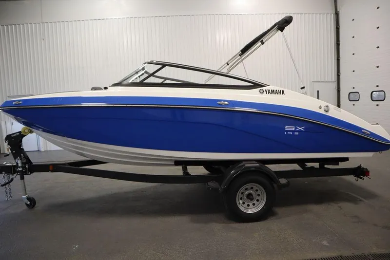 Slide: The Image of 2025 Yamaha Boats SX195 in blue and white on a trailer in a garage. - 13