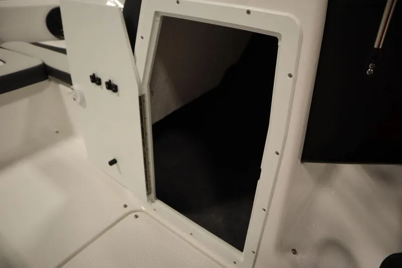 Slide: The Image of 2025 Yamaha Boats SX195 interior storage compartment with open door, showcasing sleek design. - 15