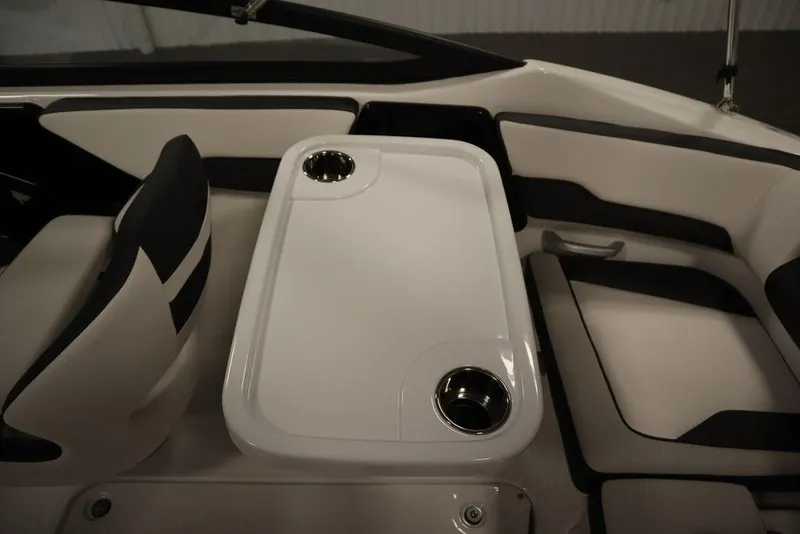 Slide: The Image of Interior of 2025 Yamaha SX195 boat featuring seating and a table with cup holders. - 39