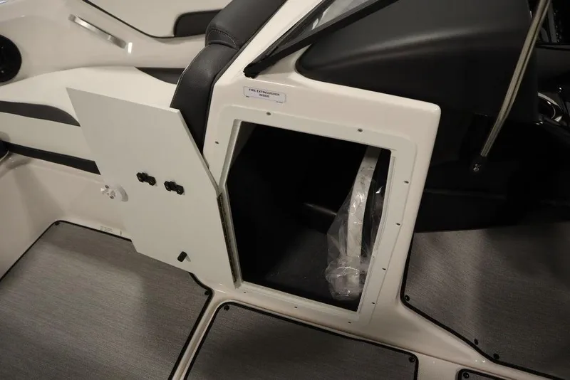 Slide: The Image of 2025 Yamaha Boats SX195 interior storage compartment with open door, showcasing sleek design. - 12