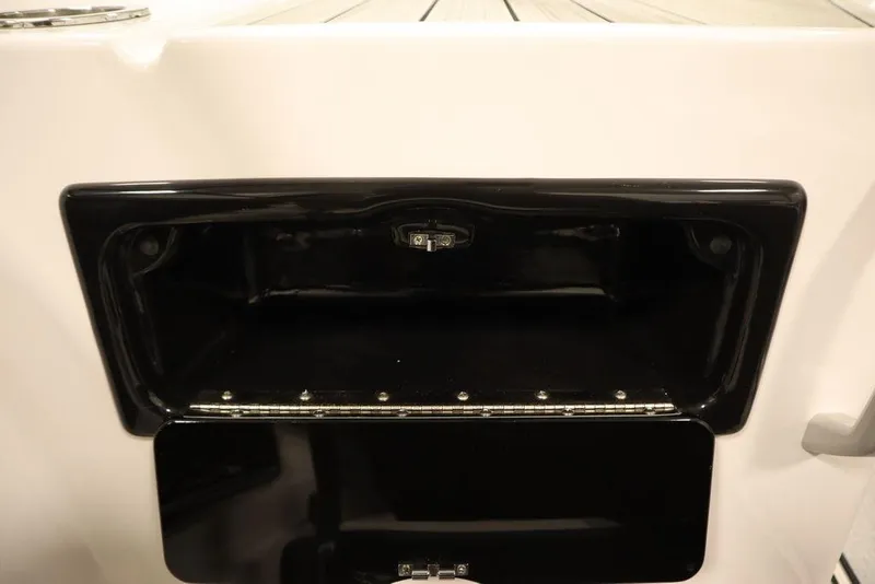 Slide: The Image of 2025 Yamaha Boats SX195 storage compartment, open and empty, with sleek black interior. - 24