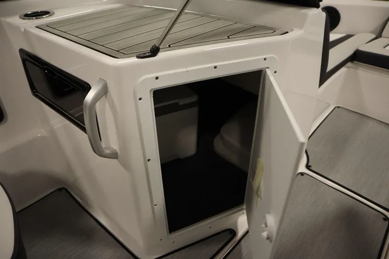 Slide: The Image of 2025 Yamaha Boats SX195 storage compartment with open door, showcasing interior space. - 26