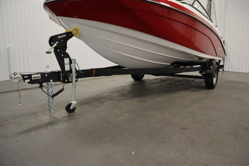 Slide: The Image of 2025 Yamaha Boats SX195 on trailer, red and white hull, indoor setting. - 39