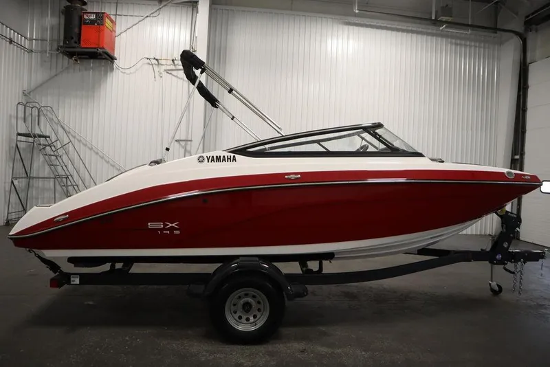 Slide: The Image of 2025 Yamaha Boats SX195 in a showroom, red and white design on trailer. - 51