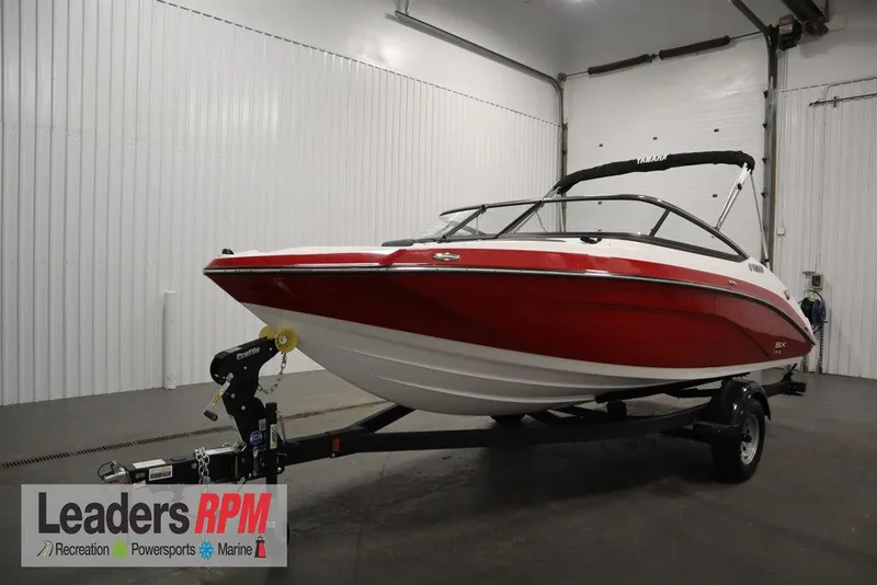 The Image of 2025 Yamaha Boats 195 SX in showroom, red and white design, on trailer. - 1