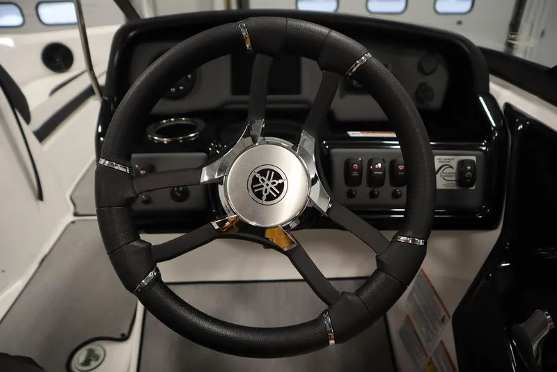 Slide: The Image of Steering wheel of 2025 Yamaha Boats 195 SX, featuring sleek black and silver design. - 24