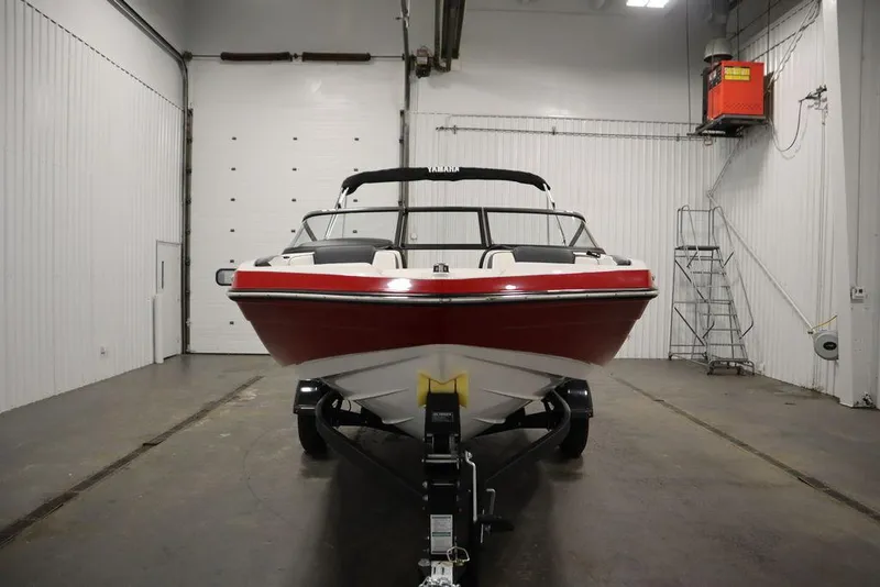Slide: The Image of 2025 Yamaha Boats 195 SX in a garage, front view, red and white design. - 3
