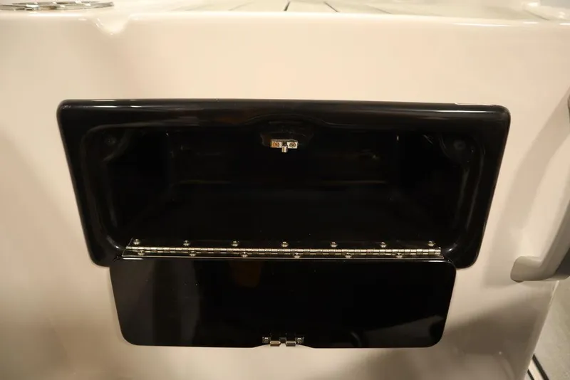 Slide: The Image of Yamaha Boats 195 SX 2025 storage compartment, black interior, open lid. - 36