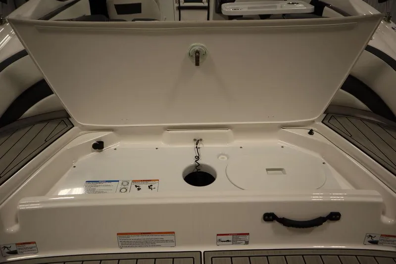 Slide: The Image of 2025 Yamaha Boats 195 SX storage compartment with open lid, showcasing interior features. - 46