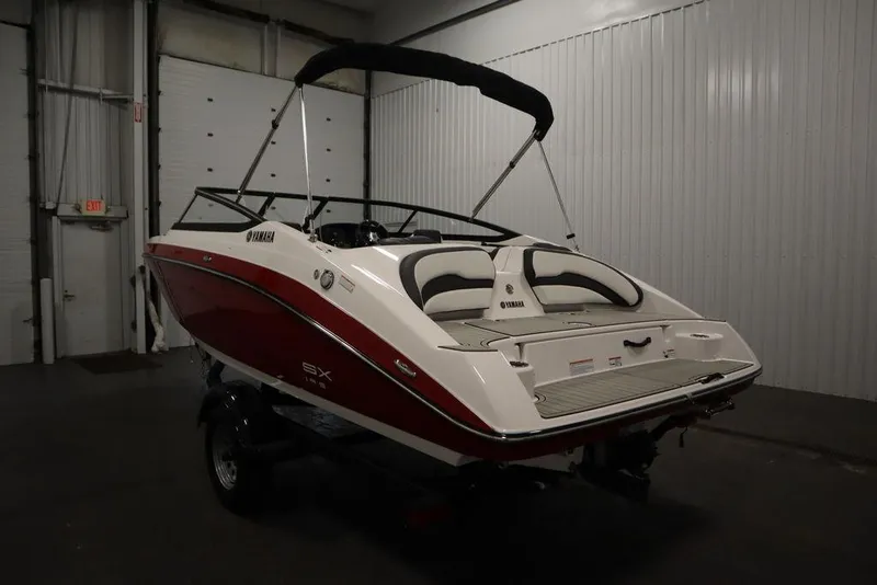 Slide: The Image of 2025 Yamaha Boats 195 SX in a garage, rear view with red and white design. - 7