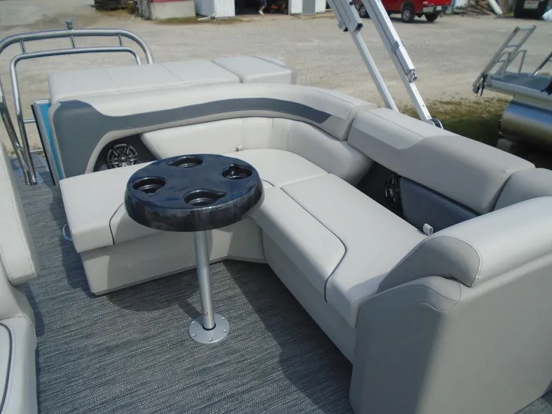 Slide: The Image of 2025 Godfrey Sweetwater 2286 C boat interior with plush seating and cupholder table. - 16