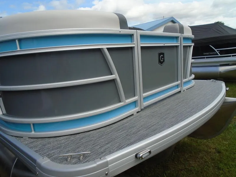 Slide: The Image of 2025 Godfrey Sweetwater 2286 C pontoon boat, silver and blue exterior, docked on grass. - 20