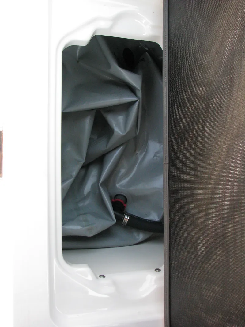 Slide: The Image of 2015 Chaparral Vortex 223 VRX-Surf ballast compartment with gray bag and hose. - 11
