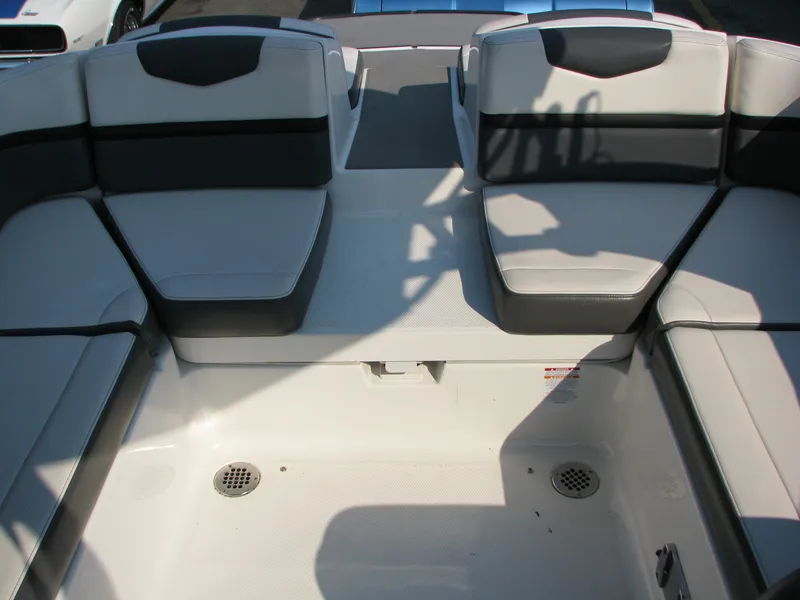 Slide: The Image of 2015 Chaparral Vortex 223 VRX-Surf boat interior with gray seating and storage area. - 14
