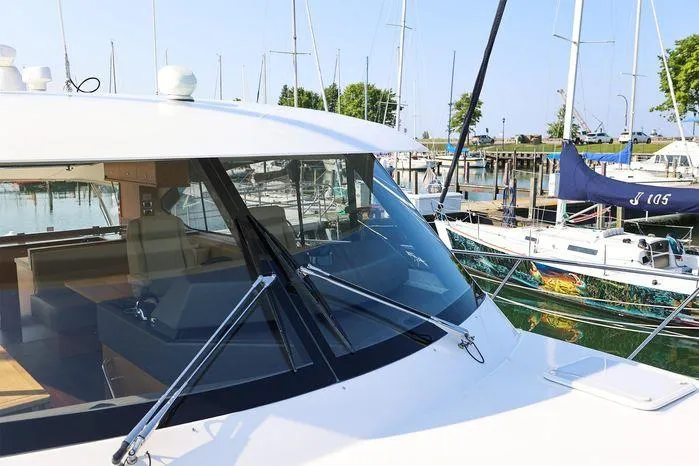 Slide: The Image of 2016 Riviera 525 SUV yacht docked at marina with sailboats in background. - 14