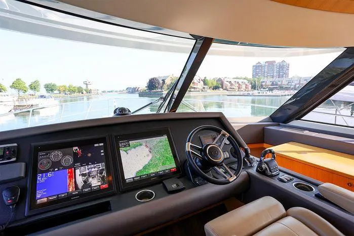 Slide: The Image of Interior view of 2016 Riviera 525 SUV yacht cockpit with navigation screens and steering wheel. - 30
