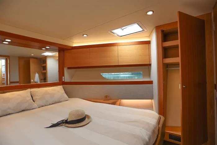 Slide: The Image of Luxurious bedroom interior of 2016 Riviera 525 SUV yacht with cozy bed and wooden cabinetry. - 35