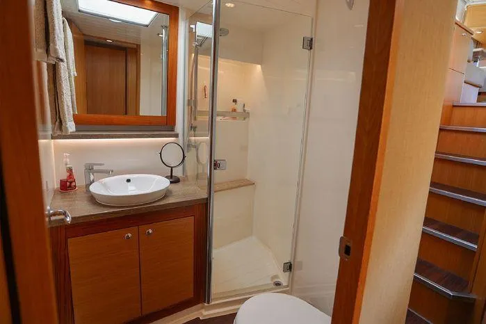 Slide: The Image of Luxurious bathroom in 2016 Riviera 525 SUV yacht with modern fixtures and wooden accents. - 41