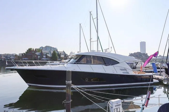 Slide: The Image of 2016 Riviera 525 SUV yacht docked in a marina, reflecting on calm water. - 8