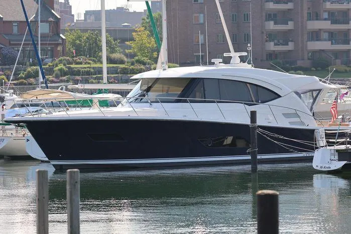 Slide: The Image of 2016 Riviera 525 SUV yacht docked in a marina, surrounded by other boats. - 9