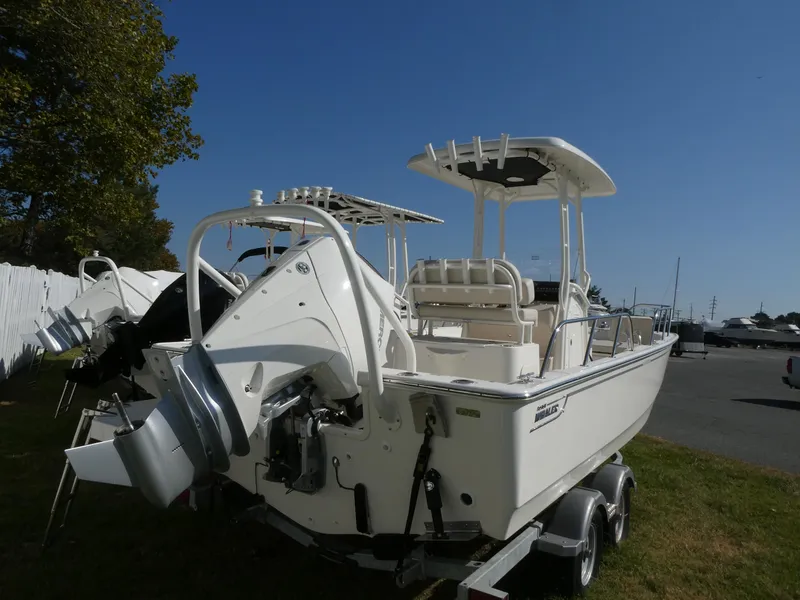 Slide: The Image of 2025 Boston Whaler 210 Montauk boat on trailer, parked outdoors. - 3