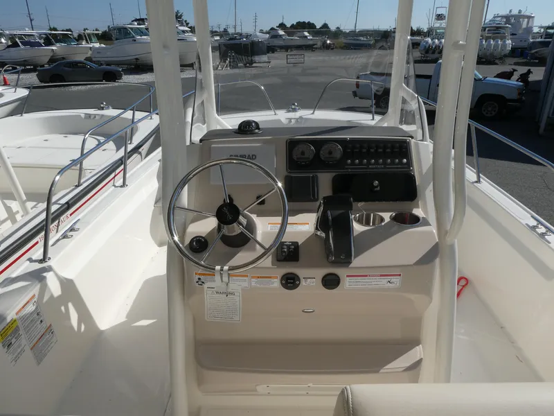 Slide: The Image of 2025 Boston Whaler 210 Montauk boat console with steering wheel and controls. - 5
