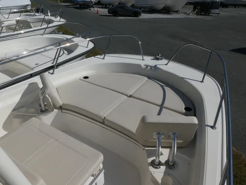 Slide: The Image of 2025 Boston Whaler 210 Montauk boat interior with cushioned seating and stainless steel railings. - 7