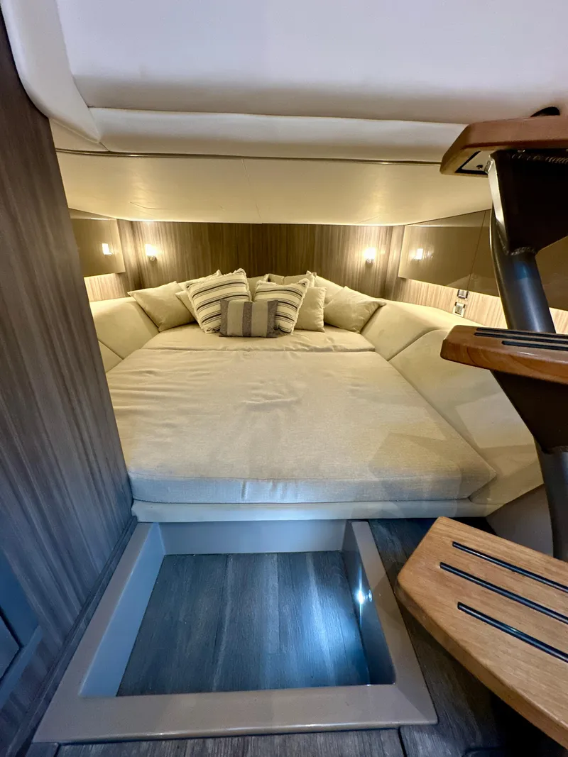Slide: The Image of 2021 Sea Ray SLX 400 Outboard cabin interior with cozy bed and ambient lighting. - 18