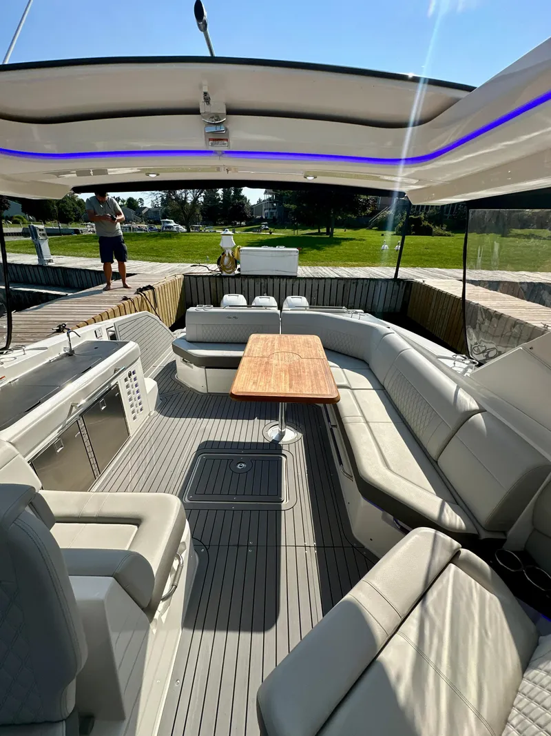 Slide: The Image of 2021 Sea Ray SLX 400 Outboard interior with spacious seating and wooden table. - 23