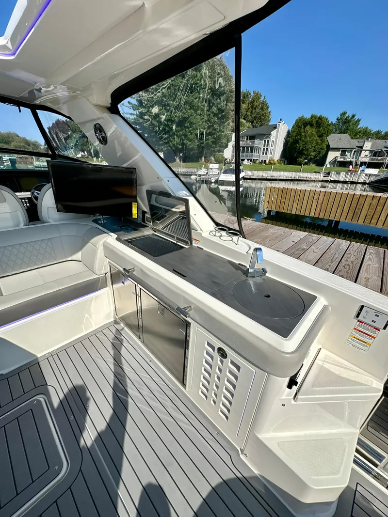 Slide: The Image of 2021 Sea Ray SLX 400 Outboard interior with sleek kitchenette and waterfront view. - 25