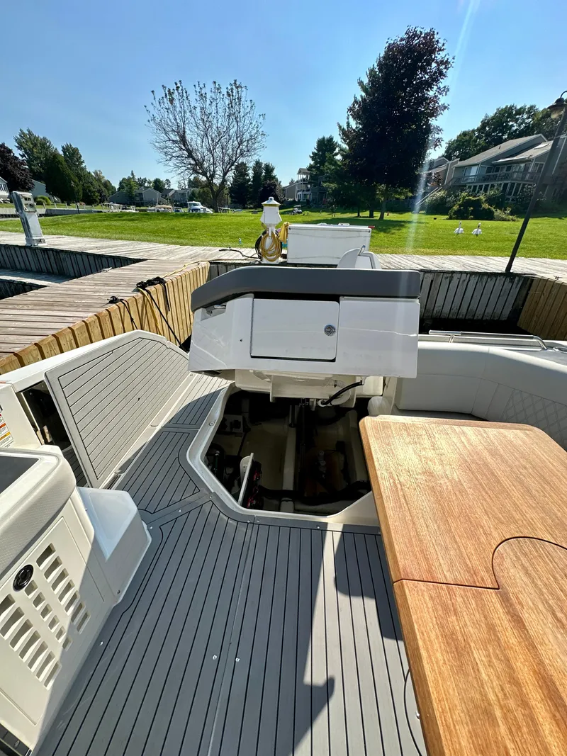 Slide: The Image of 2021 Sea Ray SLX 400 Outboard boat interior with wooden table and seating area. - 27