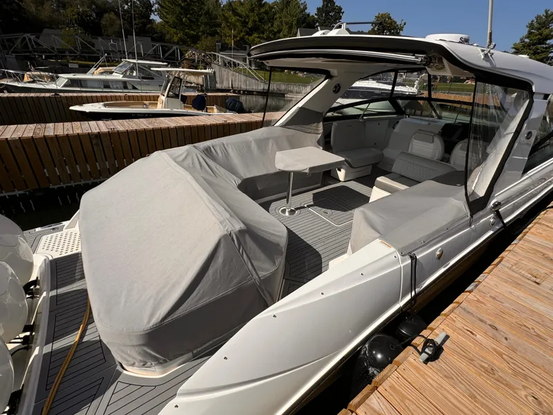 Slide: The Image of 2021 Sea Ray SLX 400 Outboard boat docked, featuring covered seating and sleek design. - 29
