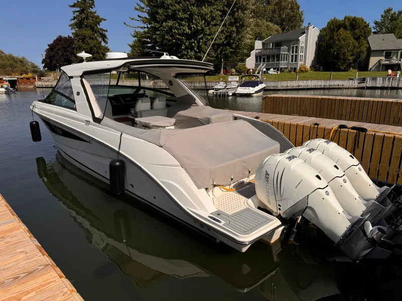Slide: The Image of 2021 Sea Ray SLX 400 Outboard docked in a serene waterfront setting. - 32