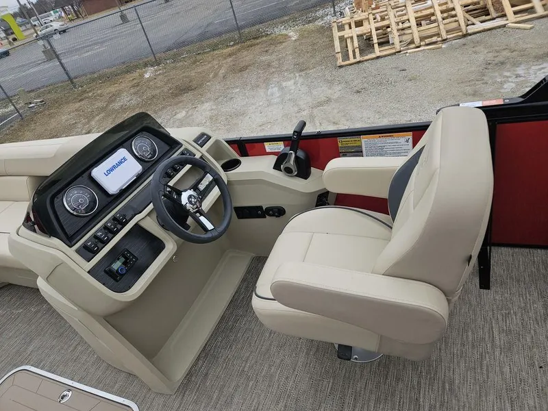 Slide: The Image of 2025 Godfrey Sweetwater 2286 SFL boat helm with beige captain's chair and control panel. - 11