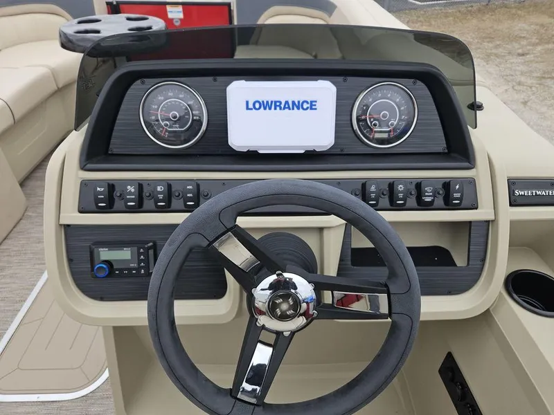 Slide: The Image of 2025 Godfrey Sweetwater 2286 SFL boat dashboard with Lowrance display and steering wheel. - 3