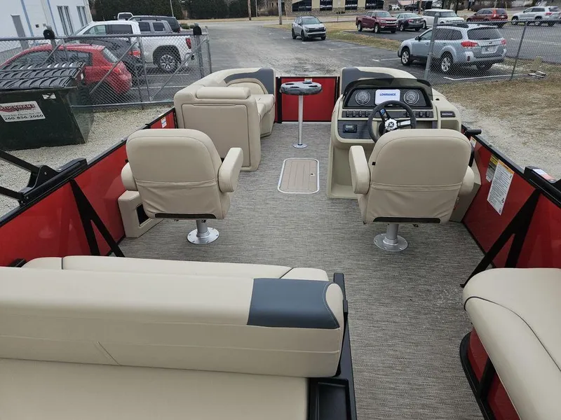 Slide: The Image of 2025 Godfrey Sweetwater 2286 SFL GTP pontoon boat interior with beige seating and steering console. - 4