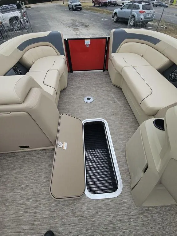 Slide: The Image of 2025 Godfrey Sweetwater 2286 SFL boat interior with beige seating and storage compartment. - 8