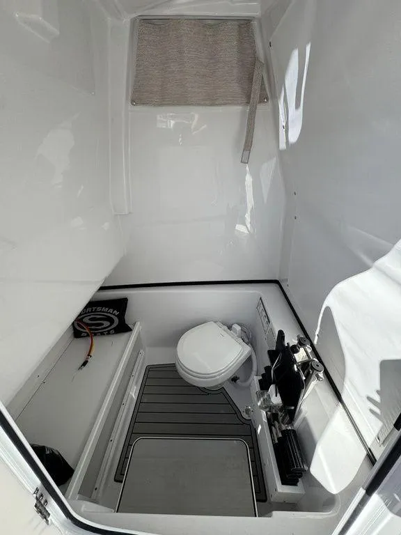 Slide: The Image of 2025 Sportsman Open 282 boat interior with toilet and storage area. - 15