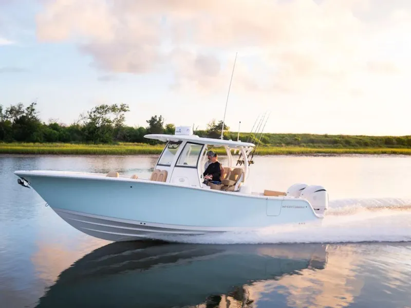 Slide: The Image of 2025 Sportsman Open 282 boat cruising on a serene lake at sunset. - 21