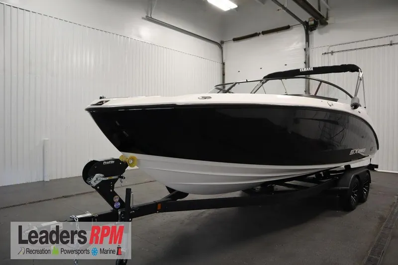 Slide: The Image of 2025 Yamaha Boats 250 SX in showroom, black and white design, on trailer. - 0