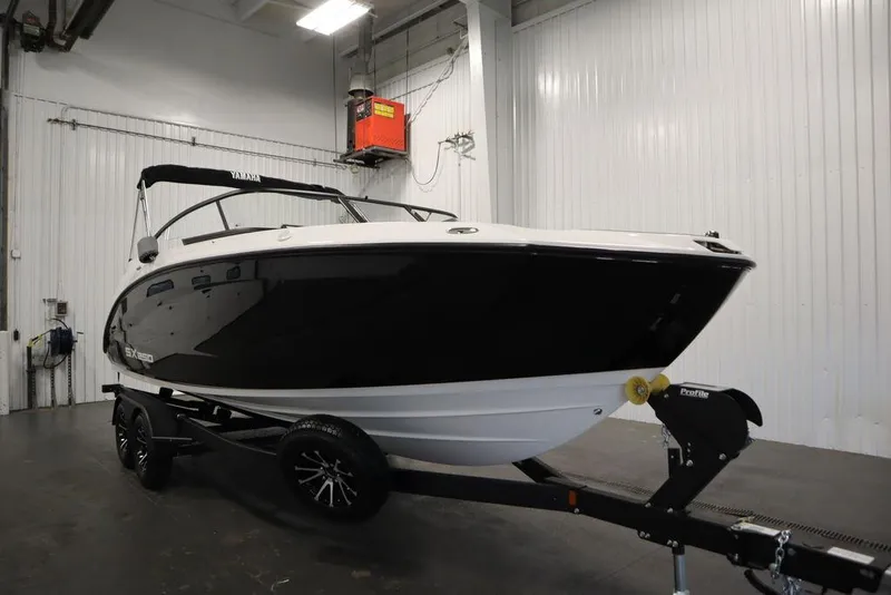 Slide: The Image of 2025 Yamaha Boats 250 SX in a showroom, black and white design on a trailer. - 2