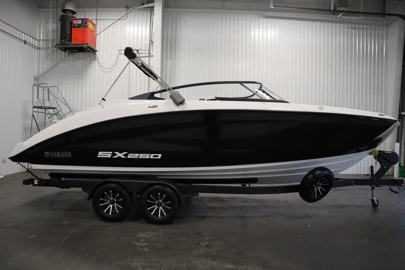 Slide: The Image of 2025 Yamaha Boats 250 SX in showroom, sleek black and white design. - 3