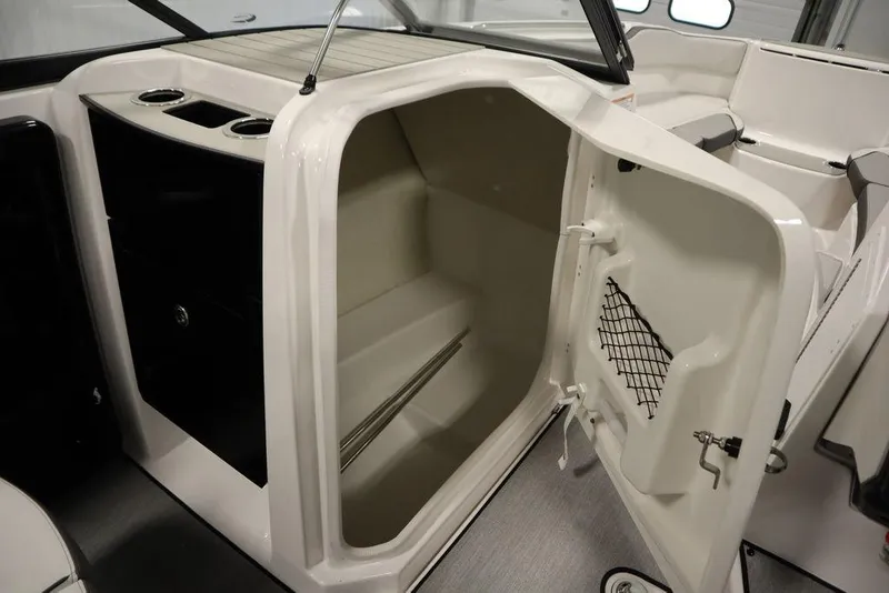Slide: The Image of 2025 Yamaha Boats 250 SX interior storage compartment with open door. - 33