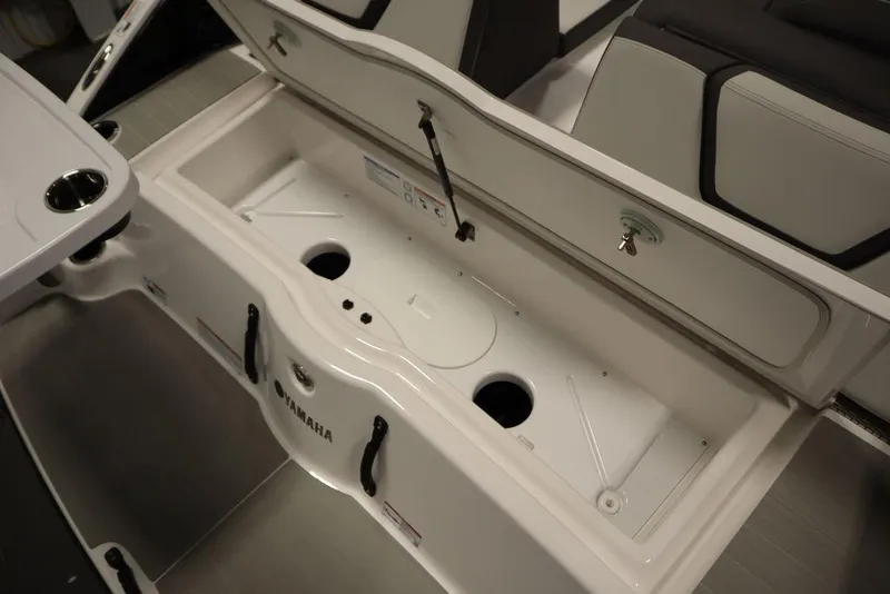 Slide: The Image of 2025 Yamaha Boats 250 SX storage compartment with open lid, showcasing interior design. - 44