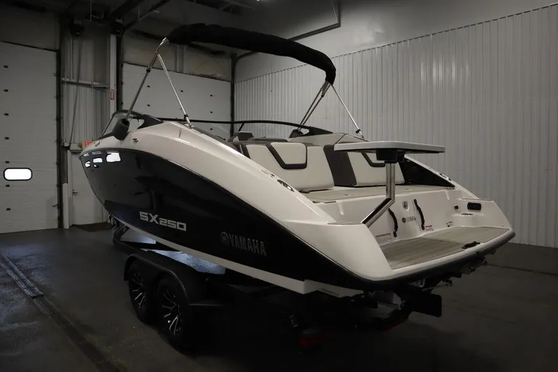 Slide: The Image of 2025 Yamaha Boats 250 SX in a garage, rear view, black and white design. - 6