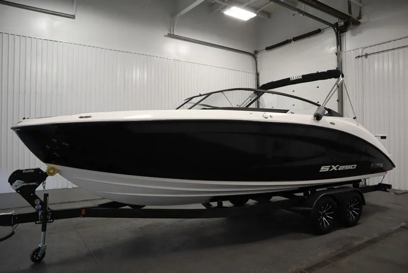 Slide: The Image of 2025 Yamaha Boats 250 SX in showroom, sleek black and white design. - 7